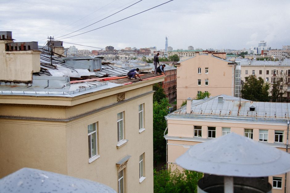 Екип от строители на място при работа на ремонт на жилищна сграда